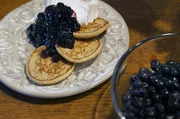 Kristi serviert ihre typisch estl&auml;ndischen Pfannkuchen mit Blaubeermarmelade und Schlagsahne.