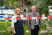 Polizeidirektor Achtziger (Alexander Duda, r.) und die Miteigentümerin der Gärtnerei, Renate Hauff (Angela Jacobi, l.), warten auf Zutritt ins Gewächshaus, damit Achtziger einen Rosenstock kaufen kann. Polizeidirektor Achtziger (Alexander Duda, r.) und die Miteigentümerin der Gärtnerei, Renate Hauff (Angela Jacobi, l.), warten auf Zutritt ins Gewächshaus, damit Achtziger einen Rosenstock kaufen kann.