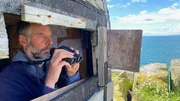 Vogelwart Mark Newell im Beobachtungsstand auf der Isle of May Vogelwart Mark Newell im Beobachtungsstand auf der Isle of May