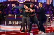 Moderator Kai Pflaume (r.) feuert mit Unterst&uuml;tzung des Publikums, den ehemaligen Gewichtheber Matthias Steiner (v.l.) an, Elton (v.M.) zu stemmen.