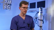 Mönchengladbach: Der junge Arzt Lorenz beantwortet während eines Interviews scheinbar eine Frage. Hinter ihm befinden sich eine große OP-Leuchte und eine Sauerstoffflasche. Das Licht im ITV-Set ist bläulich. Mönchengladbach: Der junge Arzt Lorenz beantwortet während eines Interviews scheinbar eine Frage. Hinter ihm befinden sich eine große OP-Leuchte und eine Sauerstoffflasche. Das Licht im ITV-Set ist bläulich.