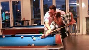 Joshua Weinstein smiles and helps Kimberly Menzies shoot the cue ball in a bar. Joshua Weinstein smiles and helps Kimberly Menzies shoot the cue ball in a bar.