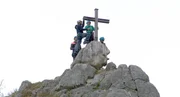 Hoch oben am Gipfelkreuz ist die Klettergruppe nun angekommen! (v. l. n. r.) Maral, Klettertrainer Martin, Melina und Bruder Fabio. Hoch oben am Gipfelkreuz ist die Klettergruppe nun angekommen! (v. l. n. r.) Maral, Klettertrainer Martin, Melina und Bruder Fabio.