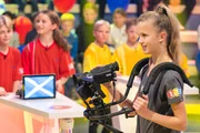 Kamerakind Kira hält die Szene mit einer professionellen Kamera fest. Kamerakind Kira hält die Szene mit einer professionellen Kamera fest.
