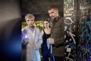 Trebbe (Simon Böer, r.) und Rossi (Anna Stieblich, l.) untersuchen eine Leiche in einer Clubtoilette. Linn (Natascha Kuch, M.) beobachtet die beiden besorgt. Trebbe (Simon Böer, r.) und Rossi (Anna Stieblich, l.) untersuchen eine Leiche in einer Clubtoilette. Linn (Natascha Kuch, M.) beobachtet die beiden besorgt.