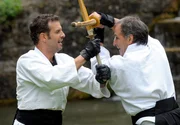 Nils (Florian Stadler, l.) l&auml;sst seinen Emotionen gegen Curd (Holger Gotha, r.) im Stockkampf freien Lauf.