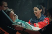 Dr. Jordan (Hanife Sylejmani, r.) erkl&auml;rt der gerade eben erst gefundenen Lydia (Maria Riaboshapka, l.), dass sie eine Thoraxdrainage legen muss, um ihr das Atmen zu erleichtern.