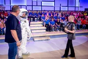 Warum dürfen Astronauten im All ihre Zahnpasta nicht einfach ausspucken? Die Rateteams aus Sachsen, Niedersachsen und Baden-Württemberg wollen es herausfinden. Von links: Elton, ein Mann im Astronautenanzug, Kamerakind Jonna Warum dürfen Astronauten im All ihre Zahnpasta nicht einfach ausspucken? Die Rateteams aus Sachsen, Niedersachsen und Baden-Württemberg wollen es herausfinden. Von links: Elton, ein Mann im Astronautenanzug, Kamerakind Jonna