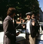 Theo Schulz, der fl&uuml;chtige Verbrecher (Ralph Schicha, links) bedroht den Taxifahrer Grabfelder (Max Grie&szlig;er) mit seiner Pistole.
