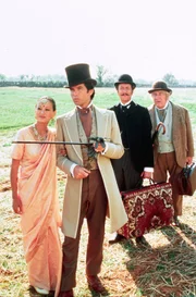 Mit Detektiv Fix (Peter Ustinov, re.) dicht auf seinen Fersen setzt Phileas Fogg (Pierce Brosnan, 2.v.l.) mit Jean Passepartout (Eric Idle, 2.v.r.) und Prinzessin Aouda (Julia Nickson) seine Reise um die Welt fort.