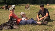 Die Milchbauern Anja und Januschz mit ihrem Sohn und Hund auf der Jungviehwiese.