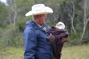 Warden Mike Boone holding an injured bald eagle.