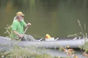 A fisherman canoeing in Alligator alley.