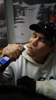 Saga deckhand, Sean Dunlop lights a cigarette in the galley.