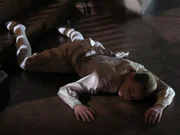 Servant Child's body is lying dead at the bottom of the staircase.