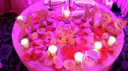 A pink table with "Mr" and "Mrs" decorations and flowers.
