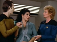 Dr. Pulaski (Diana Muldaur, r.) und Data (Brent Spiner, l.) stehen Deanna Troi (Marina Sirtis, m.) zu Beginn der zweiten Staffel bei ihrer überraschenden Schwangerschaft bei