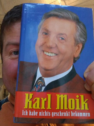 Der Autor dieses Textes mit der Autobiographie von Karl Moik