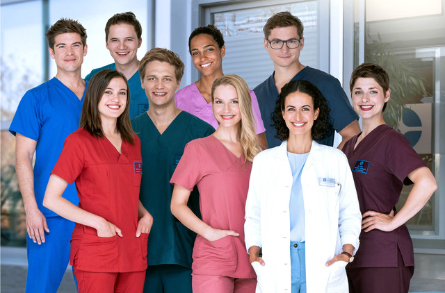 Der Cast von "In aller Freundschaft - Die jungen Ärzte": Hintere Reihe v. l. n. r.: Ben Ahlbeck (Philipp Danne), Tom Zondek (Tilman Pörzgen), Dr. Emma Jahn (Elisa Agbaglah), Dr. Elias Bähr (Stefan Ruppe). Vordere Reihe v. l. n. r.: Rebecca Krieger (Milena Straube), Mikko Rantala (Luan Gummich), Julia Berger (Mirka Pigulla), Dr. Leyla Sherbaz (Sanam Afrashteh), Dr. Theresa Koschka (Katharina Nesytowa).