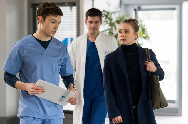 Florian (Lion Wasczyk, l.) mit Kollege Ben Ahlbeck (Philipp Danne, m.) und einer JTK-Patientin