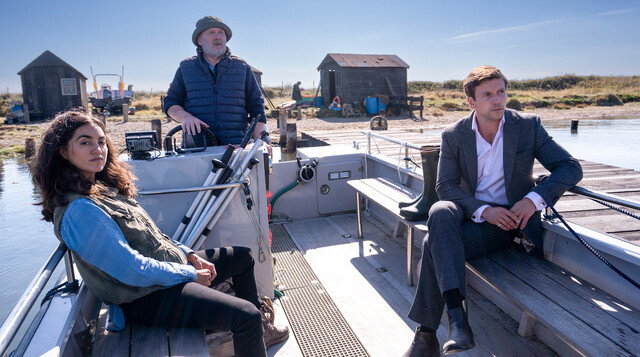 F&auml;hrmann Tony Shannon (Andrew Redman, M.) steuert ruhig und sicher das Boot mit DS Barbara Havers (Sofia Barclay) und DI Thomas Lynley (Leo Suter).