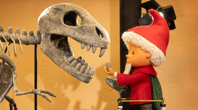 Das Sandmännchen setzt den Zahn an der richtigen Stelle des Dinosaurier-Skeletts ein.