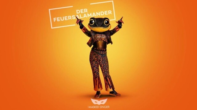 "Der Feuersalamander will bei 'The Masked Singer' nicht nur mit seinem Gesang begeistern, sondern auch mit einer spektakulären Feuer-Show. Um den holografischen Feuereffekt auf seiner Kleidung zu erzeugen, wurden glänzende Folien vielfach übereinander geschichtet. Die Lederjacke ist zusätzlich mit über 2.000 Strass-Steinen bestickt."
